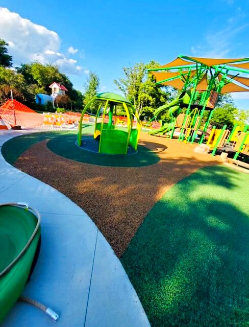 Community park multi-unit play structure on brown rubber