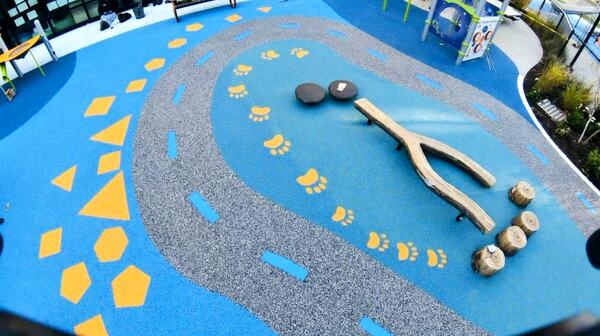 Urban park themed safety surface with paw prints